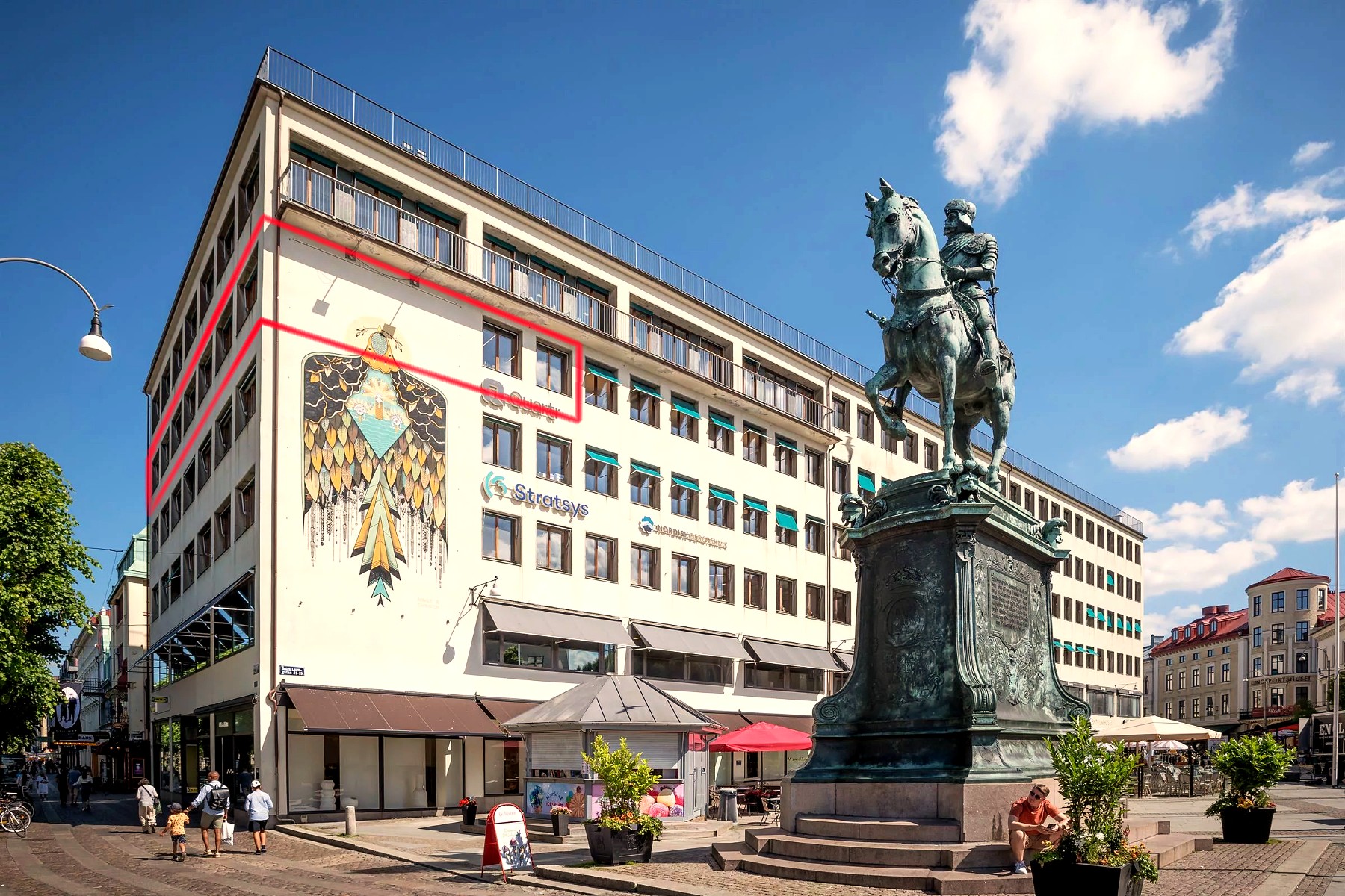 Centrumhuset vid Kungsportsplatsen med statyn Kopparmärra i förgrunden. Röd markering visar lokalens läge i fastigheten.